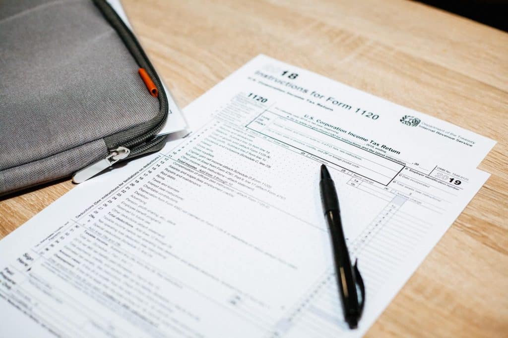 Black pen over tax documents on table